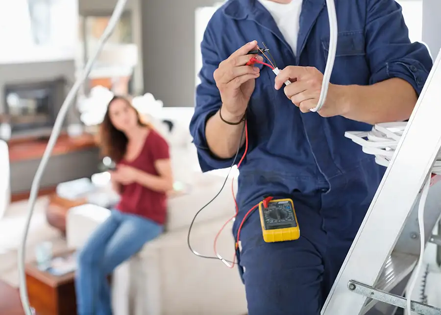 JSE Service and Electric LLC electrician connecting wiring for a new light fixture in a residential living room in O'Fallon, IL