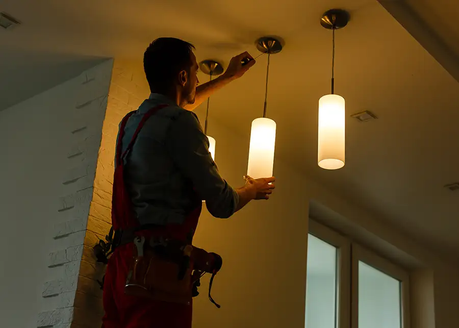 Electrician installing pendant light fixtures on a residential ceiling — JSE Service and Electric LLC serving O'Fallon, IL and St. Louis, MO