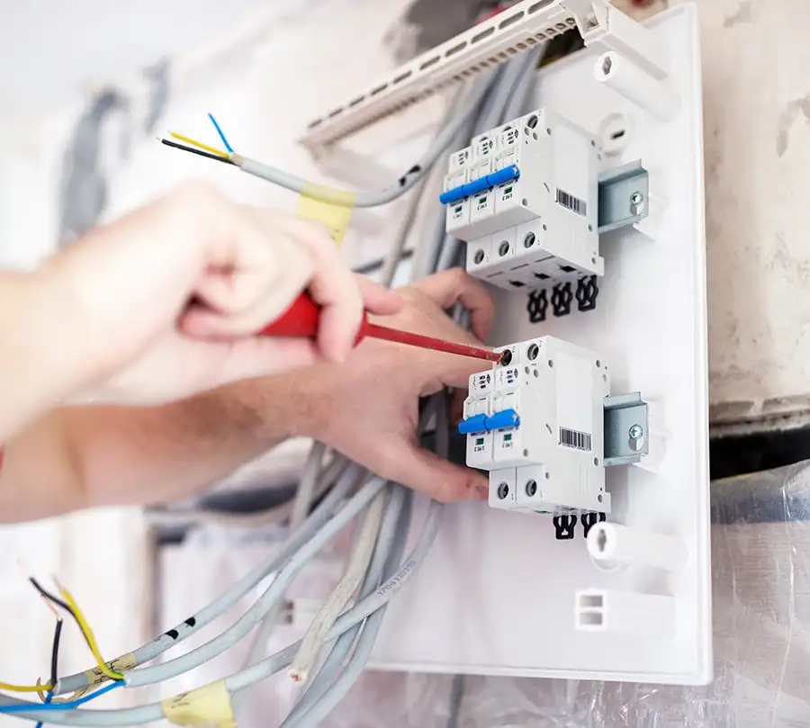 Hands of an electrician wiring circuit breakers inside an electrical panel — JSE Service and Electric LLC panel wiring services in O'Fallon, IL and St. Louis, MO