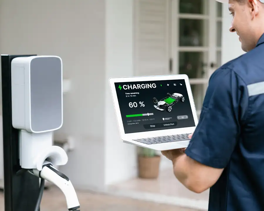 JSE Service and Electric LLC technician verifying EV charger installation using a laptop showing a vehicle charging at 60% — O'Fallon, IL and St. Louis, MO