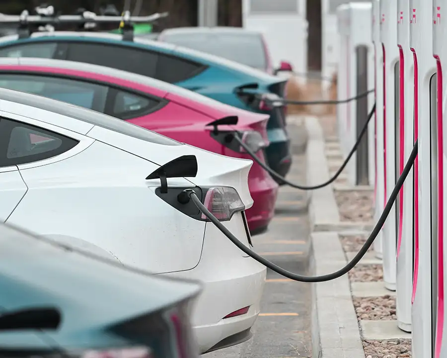 Row of electric vehicles plugged into commercial EV charging stations — JSE Service and Electric LLC installs EV chargers for any brand of Electric Vehicle in O'Fallon, IL and St. Louis, MO