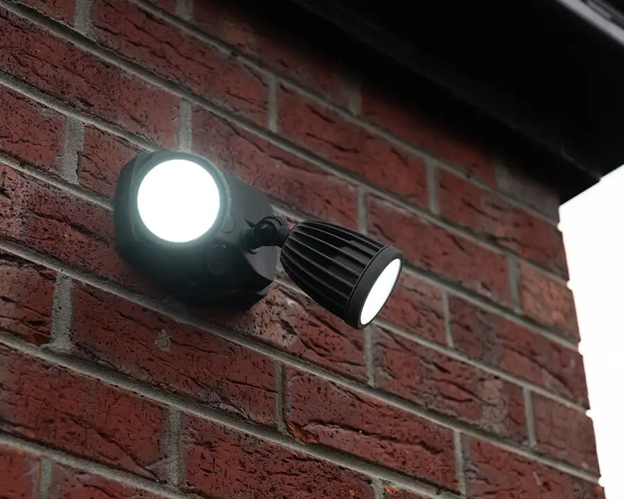 Dual-head LED security flood light mounted on a brick exterior wall — JSE Service and Electric LLC outdoor security lighting installation in O'Fallon, IL and St. Louis, MO