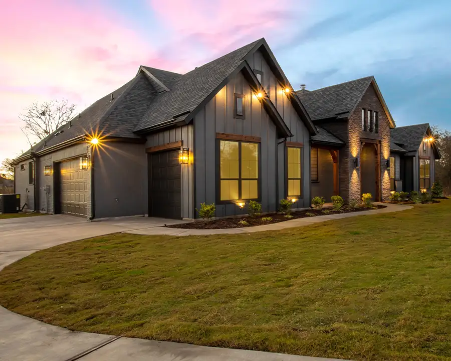 Craftsman-style Troy, IL home showcasing a full outdoor lighting setup — wall sconces, garage lights, and landscape uplighting — installed by JSE Service and Electric LLC