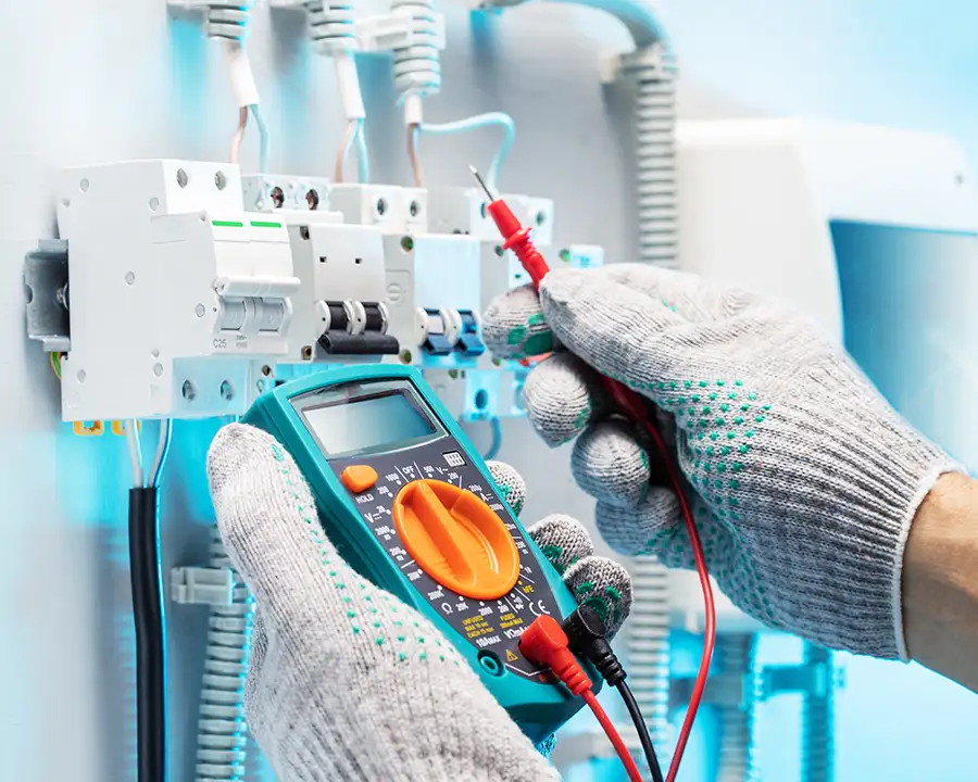 JSE Service and Electric LLC technician inserting a red test probe into a circuit breaker terminal during a Ballwin, MO electrical safety inspection