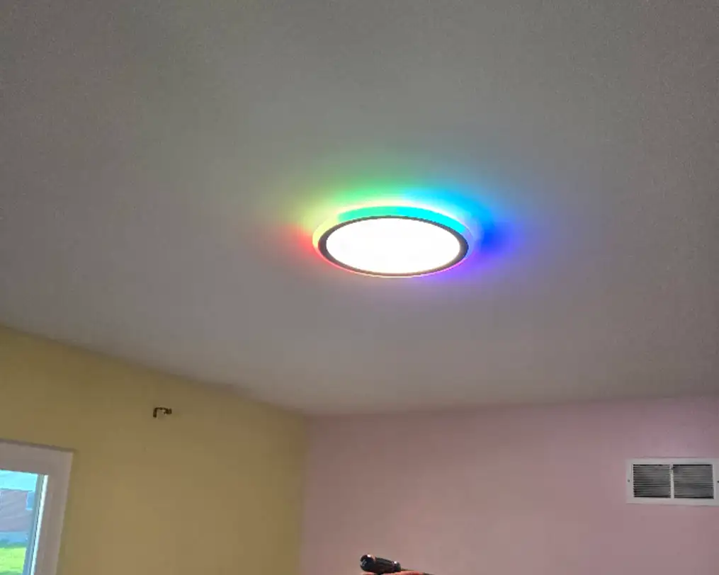 JSE Service and Electric LLC installing a color-changing RGB LED flush-mount ceiling light in a residential room in O'Fallon, IL or St. Louis, MO